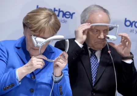 Angela Merkel and Switzerland's Johann Schneider-Ammann look at head-mounted display units.jpg