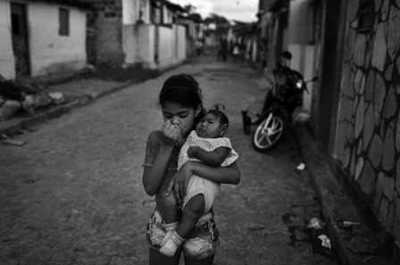 Katie Falkenberg Zika Evellyn Mendes Santos age 9 kisses her baby sister Heloyse who was born with microcephaly outside of their home in Joao Pessoa Brazil.jpg