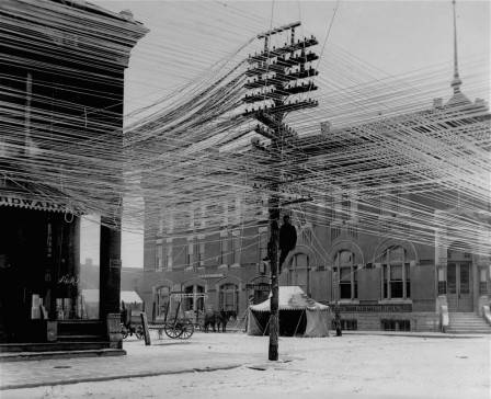 Telephone_lines_at_an_intersection_in_Pratt_Kansas_USA_1911_le_reseau_telephonique_toile_web.jpg