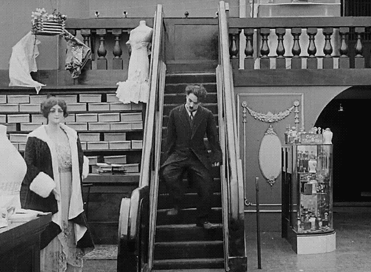 Charlot chef de rayon (The Floorwalker) - Charlie Chaplin 1916 escalator Noël, la course dans les grands magasins pour l'achat des derniers cadeaux.gif, déc. 2021