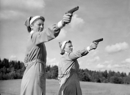 Weda idrottsanläggning. Lottor tränar pistolskytte på idrottsledarkurs i Roslagen.