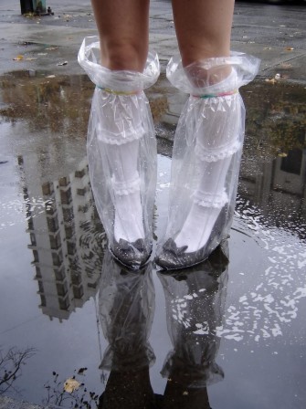 Bogdana Attila chaussettes blanches à froufrous et des ballerines noires, protégées de l'eau par des sacs en plastique transparent pluie l'automne arrive