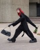 une fashionista en marche à grandes enjambées dans un élégant vêtement ample loin du corps pour profiter des derniers rabais sur la mode