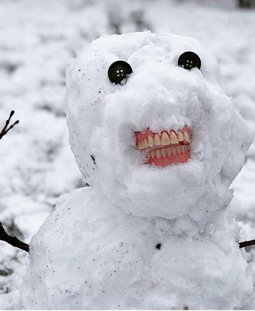 un bonhomme de neige sourit avec un dentier
