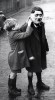 Adjusting_Adolf_Hitler_mask_on_a_street_in_King_s_Cross_London_1938.jpg