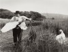 à la campagne, un homme tient un cygne dans ses bras