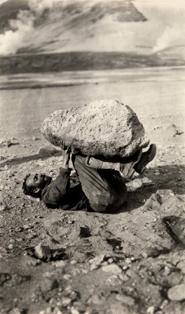 A man balances a piece of pumice rock on his legs in Katmai National Park and Preserve, Alaska, September 1921.Photograph by Lucius G. Folsom, National Geographic Sisyphe moment de détente en Alaska