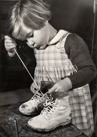 Ergy Landau. Petite fille laçant ses chaussures