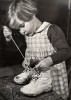 Ergy Landau. Petite fille laçant ses chaussures