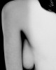 la présence d'un sein entre le torse et le bras d'une femme nue de profil