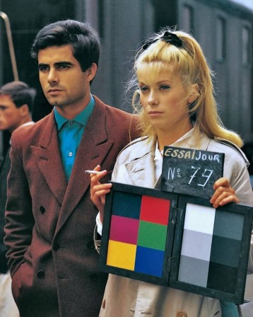 Catherine Deneuve tenant une mire de couleurs sur le tournage des parapluies