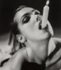 une jeune femme, une bougie allumée dans la bouche