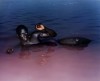 un homme noir allongé le poing levé dans la mer rose