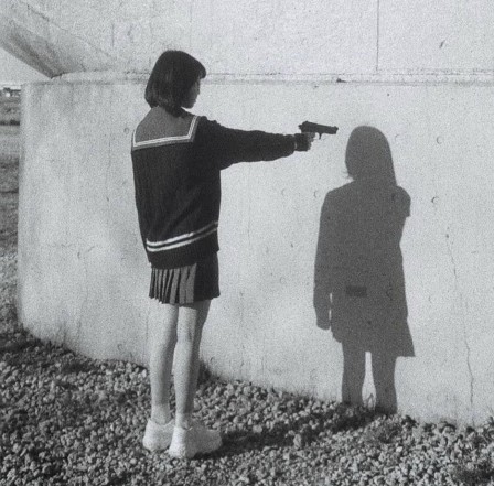 fille pointant une arme sur son ombre arrête de faire ta maline