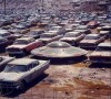 une soucoupe garée parmi des voitures abandonnées