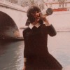sous un pont de Paris, une femme boit du vin au goulot d'une bouteille de blanc